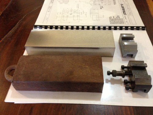 The material for the tool holders is cast iron bar from a house wreckers yard.  The bar was 3 foot lengths of iron window counterweights from very old double hung windows.  Very cheap $5 each.  A bit porous in places, but enough good stuff to get useable 300mm lengths. Roughly cut to length in foreground, machined square behind, finished article on right.